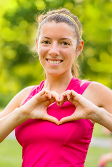 woman making heart with fingers over her heart