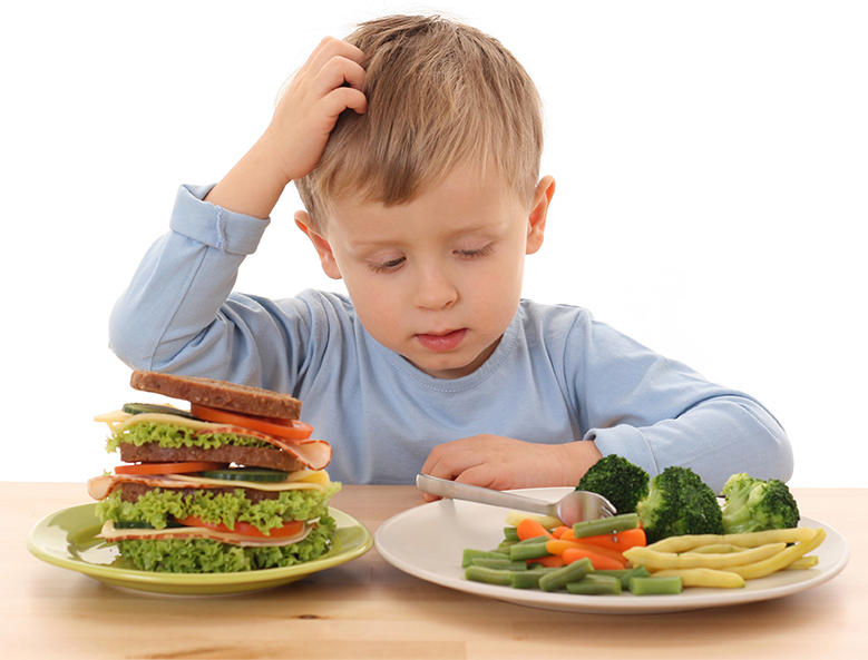 boy making a choice between veggies and a sandwich
