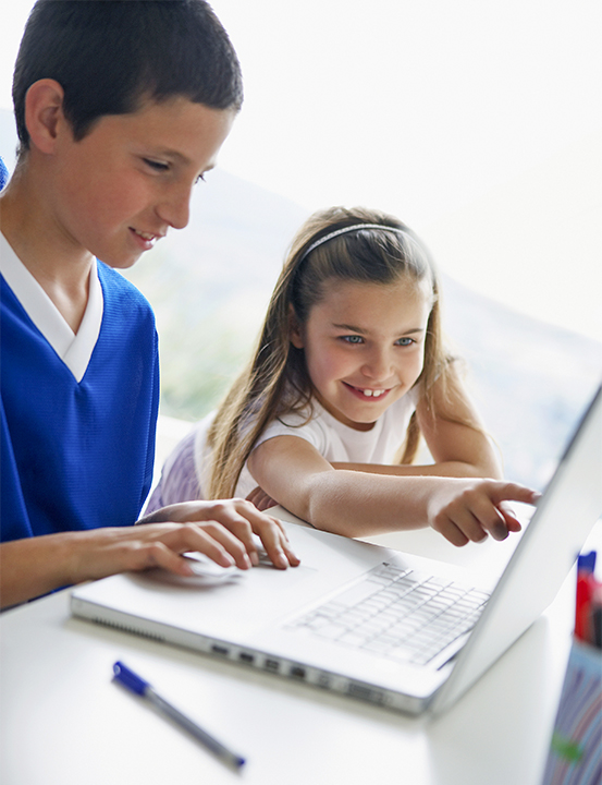 Boy Using Laptop with Sister Watching