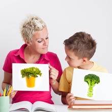 mom and son holding pictures of veggies