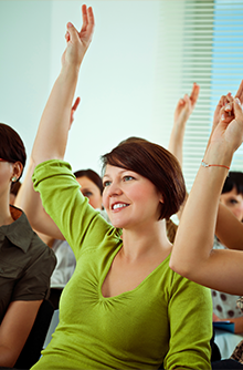 woman raising hand in class