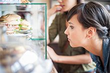 woman choosing sandwich in deli case