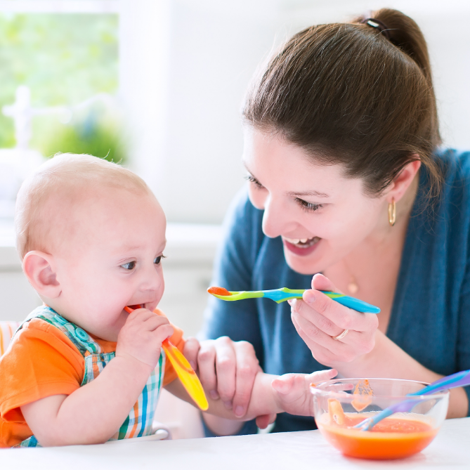 Mom feeding baby solid foods