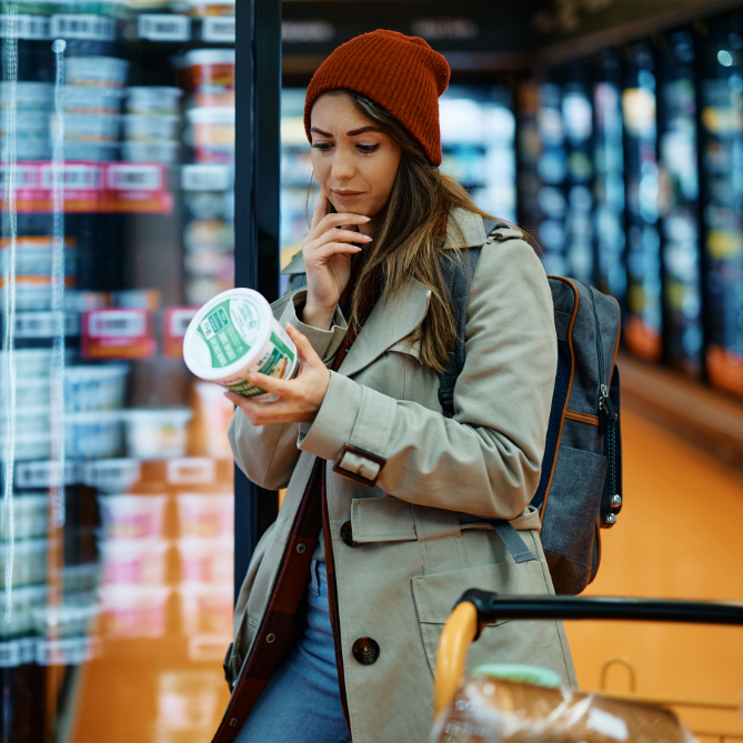 woman looking at nutrition label in the grocery store