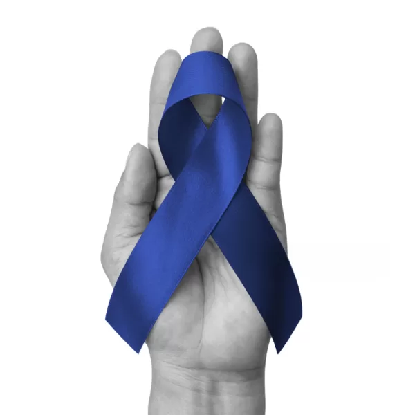 Blue ribbon on palm of hand, symbolizing colorectal cancer awareness