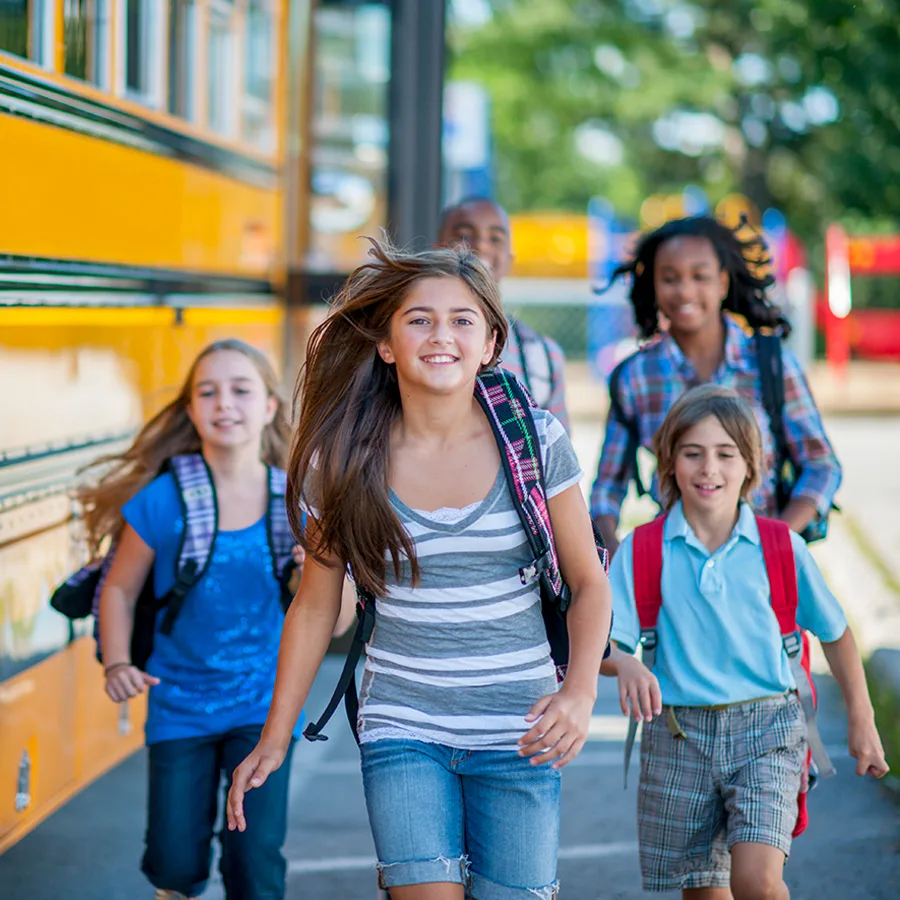 A group of kids leave a school bus